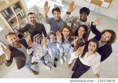 Top view of happy business people alooking at camera and raising hands voting in the office. 138170654