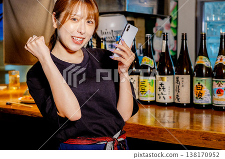 Female part-time worker at an izakaya (Japanese pub). Female part-time worker at an izakaya (Japanese pub). 138170952