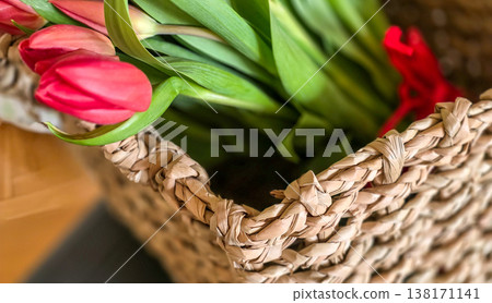 Red tulips in a basket close-up. A gift for a girl for the holidays. High quality photo 138171141