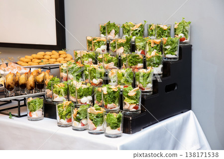 Assorted catering appetizer with caesar salad in glass verrine on buffet stand for event or party decoration with no people and copy space delicious 138171538