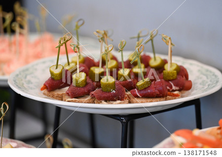 Assorted catering appetizer with beef canape and gherkin on skewer for event or party decoration with no people and copy space delicious food snack 138171548