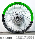 Bicolor green and black motorcycle wheel rim rear view with silver spoke and metal hub isolated on white background for motorbike tuning and repair 138171554