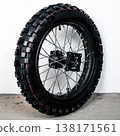 Motorcycle wheel rim with knobby tire and silver spoke in perspective view isolated on white background for dirt bike custom tuning and repair part 138171561