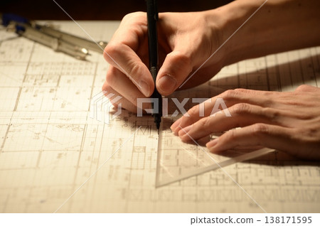 The hands of a Japanese architect drawing architectural drawings at night 138171595