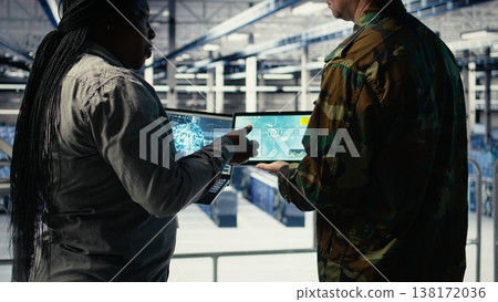 Close up of military data center colleagues looking at radar software to watch for enemy threats. Teamworking army staff members in data center scan suspicious activity to detect dangers, camera A 138172036