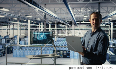 Engineer in data center checks AI dashboard using laptop during routine systems review. IT expert tests artificial intelligence tools on notebook to confirm reliable performance, camera A Engineer in data center checks AI dashboard using laptop during routine systems review. IT expert tests artificial intelligence tools on notebook to confirm reliable performance, camera A 138172060