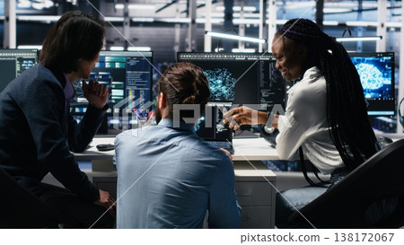Server room computer scientists using AI to review infrastructure diagnostics. IT specialists working together in data center, analyzing performance data using artificial intelligence tech, camera A 138172067