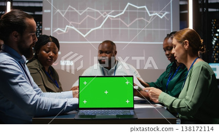 Workers group reviewing insights with chroma key after hours, analyzing annual trends and collaborating on project agenda supported by visual data. Business intel projections in a meeting. Camera A. Workers group reviewing insights with chroma key after hours, analyzing annual trends and collaborating on project agenda supported by visual data. Business intel projections in a meeting. Camera A. 138172114