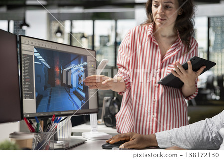 Team using programming software and commands to build fantasy video game, designing spaceship models and creating gaming assets. Immersive virtual world in creative agency office. 138172130