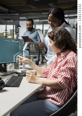 Graphic editors generate images from prompts with text to image software, performing photo retouching. Diverse staff collaborating with artificial intelligence technology on monitor. 138172181