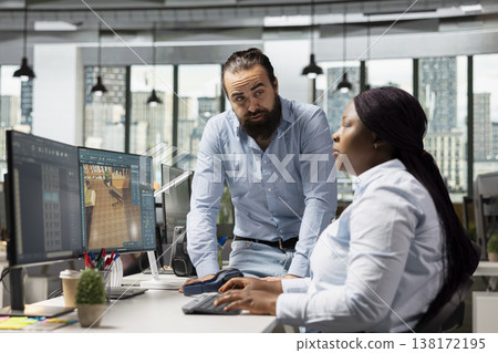 Team of diverse architectural specialists working with CAD program on computer, modern apartment layout with floor plan. 3D rendering software on dual monitors, interior design. Team of diverse architectural specialists working with CAD program on computer, modern apartment layout with floor plan. 3D rendering software on dual monitors, interior design. 138172195