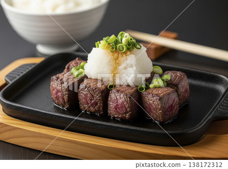 牛排丁在鐵板上烤至完美，配上日式蘿蔔泥、柚子醋和蔥花。 138172312