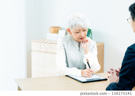 Senior woman listening to a salesperson's explanation 138173141