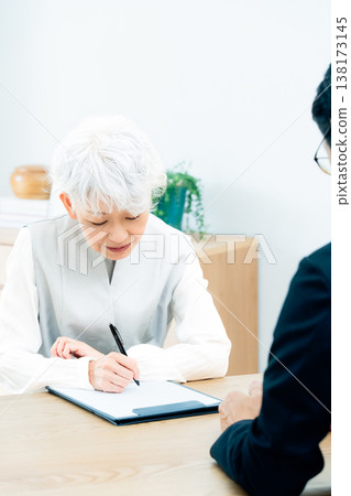 Senior woman listening to a salesperson's explanation Senior woman listening to a salesperson's explanation 138173145
