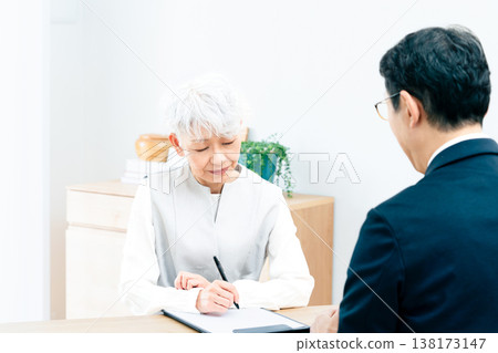 Senior woman listening to a salesperson's explanation Senior woman listening to a salesperson's explanation 138173147