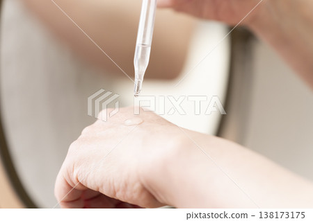 A woman's hands applying makeup. A woman's hands applying makeup. 138173175