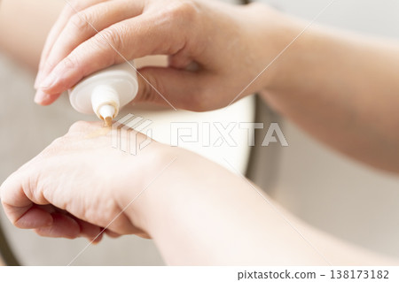 A woman's hands applying makeup. A woman's hands applying makeup. 138173182