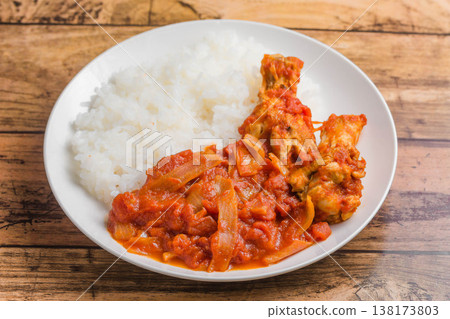 Chicken wings simmered in tomato sauce over rice Chicken wings simmered in tomato sauce over rice 138173803