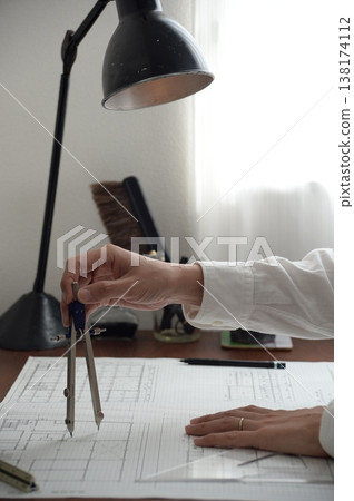 畫面中,幾隻手正在繪製建築師考試的建築圖紙,背景則是一張擺放著復古檯燈的桌子。 畫面中,幾隻手正在繪製建築師考試的建築圖紙,背景則是一張擺放著復古檯燈的桌子。 138174112