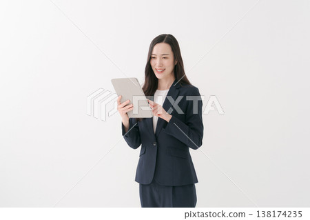 A smiling businesswoman operating a tablet PC. A smiling businesswoman operating a tablet PC. 138174235