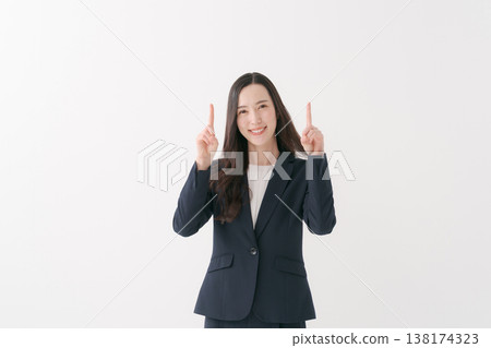 A smiling businesswoman pointing her finger A smiling businesswoman pointing her finger 138174323