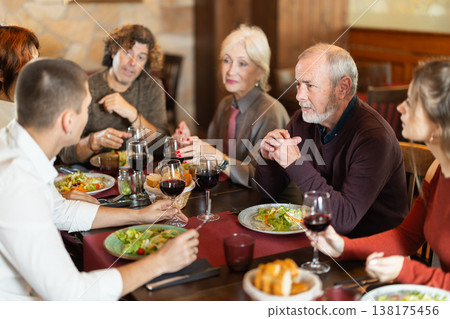Large friendly family gathered at table to have lunch in restaurant Large friendly family gathered at table to have lunch in restaurant 138175456