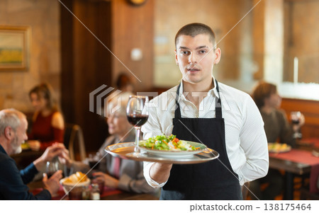 Guy waiter with tray in cafe hall 138175464