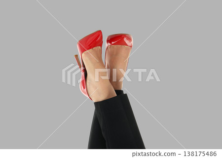 Woman shows red high heels while resting legs in space Woman shows red high heels while resting legs in space 138175486