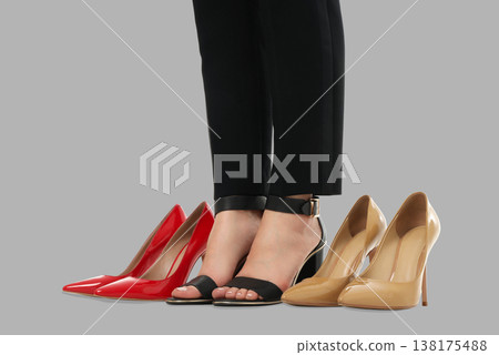 A woman shows various styles of womens shoes on display 138175488