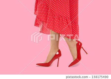 A woman wears red heels with a polka dot dress, showcasing style 138175490