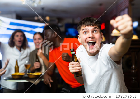 Excited guy rooting for favorite Uruguayan team in sports bar Excited guy rooting for favorite Uruguayan team in sports bar 138175515