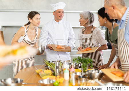 Positive chef sharing secrets of cooking salmon during culinary courses Positive chef sharing secrets of cooking salmon during culinary courses 138175541