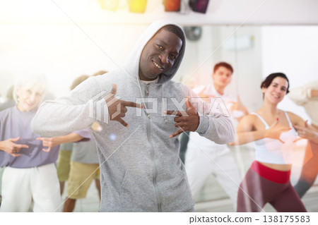 African American man practicing hip-hop movements during group class African American man practicing hip-hop movements during group class 138175583