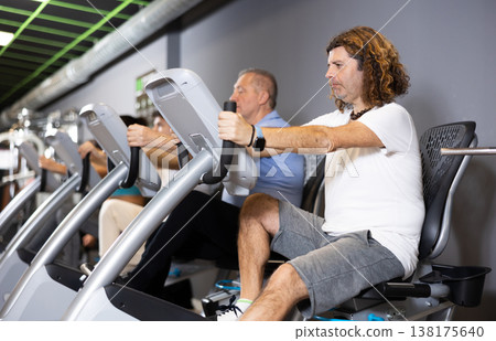 Motivated man doing cardio workout on exercise bike in gym Motivated man doing cardio workout on exercise bike in gym 138175640