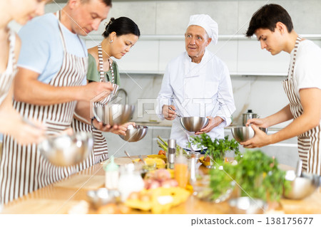 Chef teaches how to beat raw eggs with a whisk in cooking class 138175677