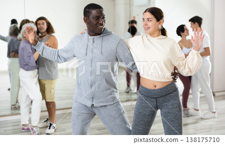 Cheerful girl and man enjoying active dancing in pair Cheerful girl and man enjoying active dancing in pair 138175710