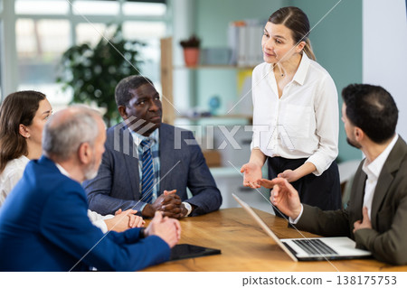 Adult woman leading meeting at office table Adult woman leading meeting at office table 138175753