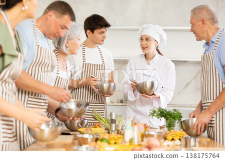 Young female cook teaches to cook group of people 138175764