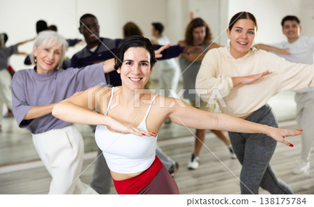 Happy Latina enjoying active dancing during group training Happy Latina enjoying active dancing during group training 138175784