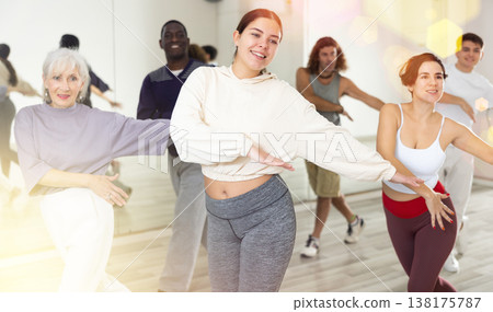Cheerful girl enjoying active dancing during group training Cheerful girl enjoying active dancing during group training 138175787