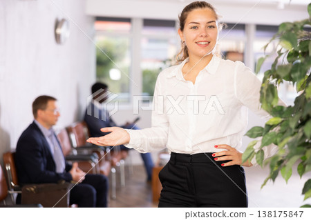 Happy young woman standing with her back to waiting room Happy young woman standing with her back to waiting room 138175847