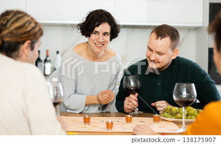 Friends drinking wine and enthusiastically playing board game at home Friends drinking wine and enthusiastically playing board game at home 138175907