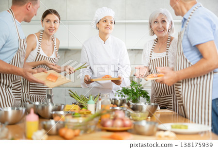 Asian woman chef sharing secrets of cooking salmon at culinary class 138175939