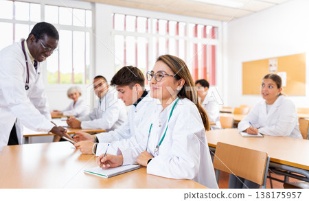 Young hispanic female medical student taking notes during group lecture Young hispanic female medical student taking notes during group lecture 138175957