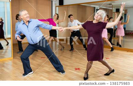 Elderly pair practicing ballroom dance in dance studio Elderly pair practicing ballroom dance in dance studio 138175983