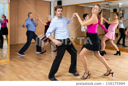 Happy couple performing a paired dance in ballroom 138175994