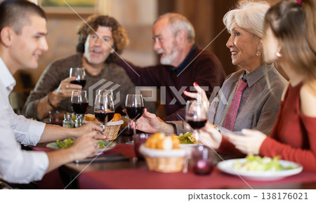 Family having dinner and talking in restaurant 138176021