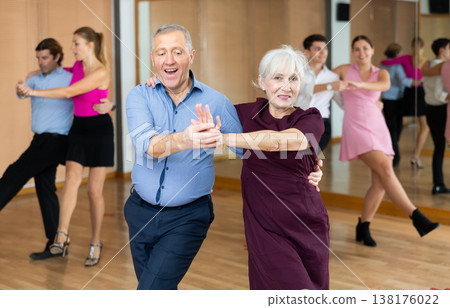 Aged couple learning partner swing in dance class Aged couple learning partner swing in dance class 138176022
