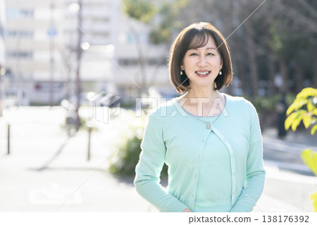 一位五十歲出頭的女士面帶微笑,直視鏡頭。 一位五十歲出頭的女士面帶微笑,直視鏡頭。 138176392