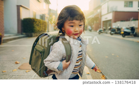 Candid documentary of a diverse young child walking to school with a backpack in natural light, showing a real life morning routine and healthy work life balance for a modern active family 138176418